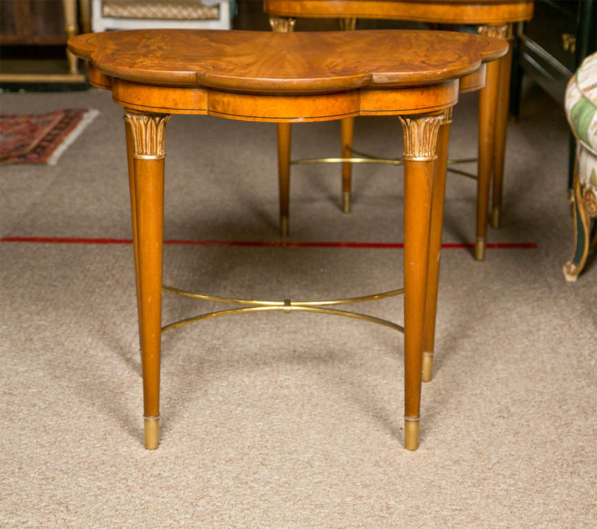 Pair of walnut handmade side tables by Parzinger for Charak Furniture, circa 1950s, the scallop-shaped top with ebony inlaid banding supported by four circular tapering legs joint by brass stretcher, ending in brass caps.