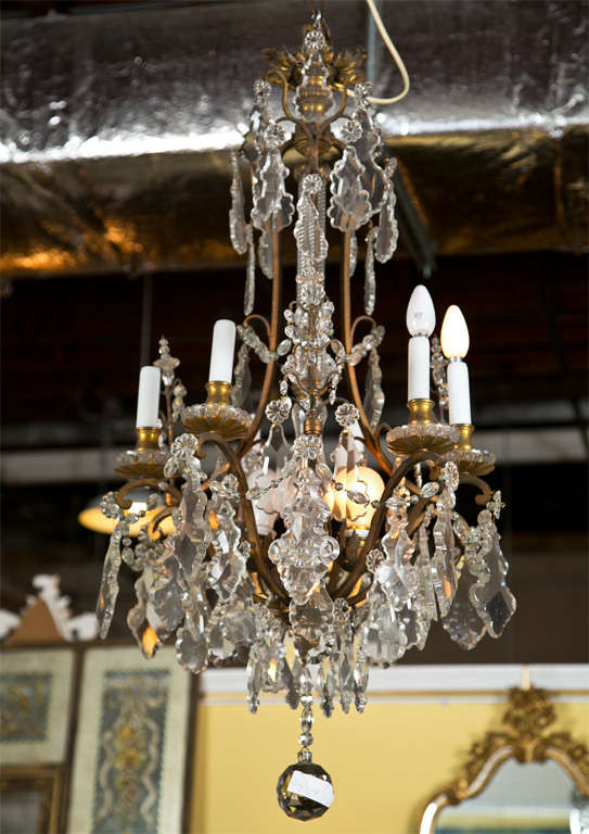 Late 19th or very early 20th century barley twist glass column center form bronze and hanging crystal chandelier. Six lights with curved bronze sides and bronze ceiling plaque. all-over early crystal hanging pendants and crystal swags ending in a