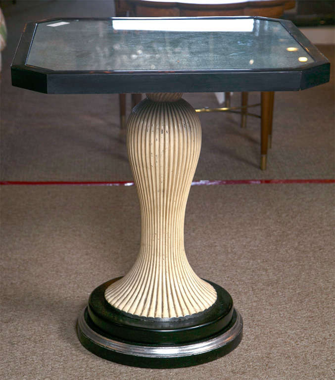 Pair of painted and ebonized end tables, circa 1940s, the silver leaf glass top supported by a fluted pedestal raised on circular base.