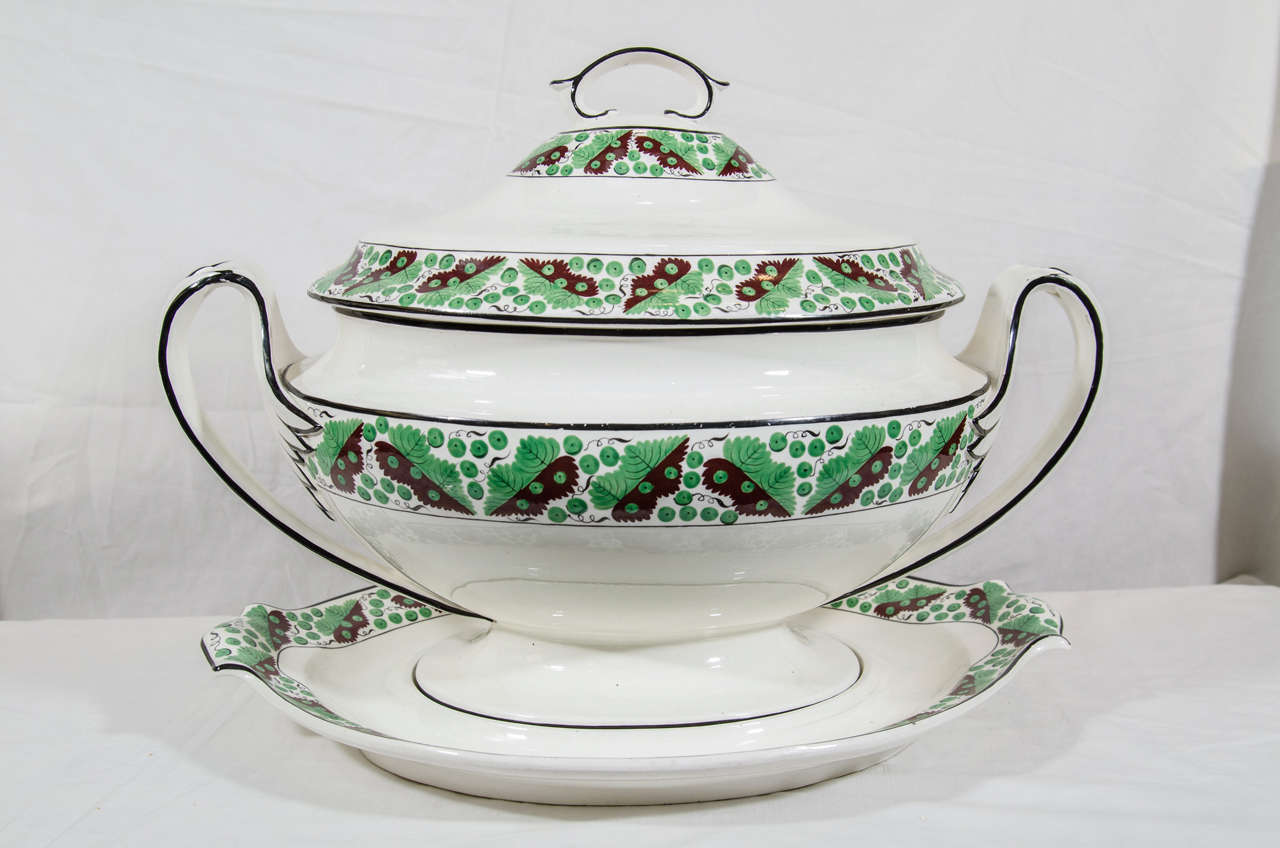 An early 19th century Spode creamware soup tureen and stand with a sleek neoclassical design, and a wide border of stylized oak leaves and acorns painted in green and brown.
We also have a pair of matching chargers (see image #8).