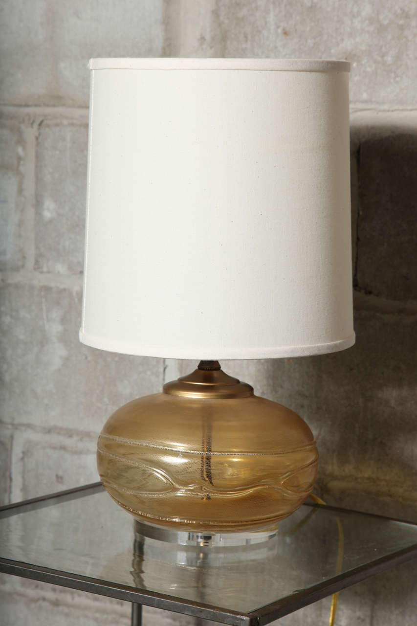 Warm, rich gold glow anchors these beautiful murano glass lamps on a lucite base.  Total height is 18