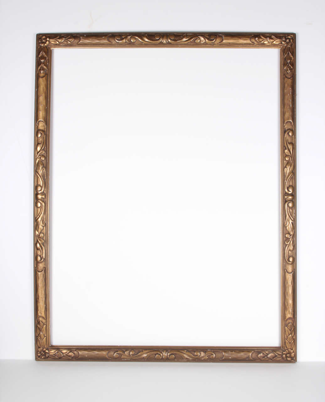 Early 20th century Arts & Crafts period frame, Foster Bros., Boston, print/watercolor frame, Roman gilded, hand carved with floral corner motif and central scroll and leaf decoration

Rabbet: 28 3/4 x 22 1/4 inches

Custom flat or beveled mirror