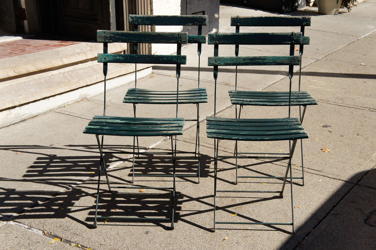 This comfortable set of four chairs from France made circa 1960 are designed for easy movement and compact storage as they fold well and become almost flat . Constructed of riveted iron frames the seats & backs are made of wood slats. The wood is in