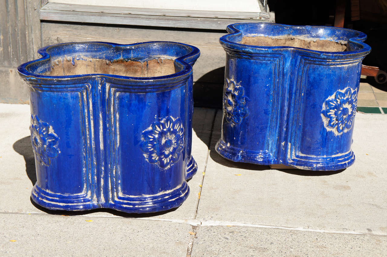 This good pair of French Faience planters are vintage and constructed from thick heavy terra cotta walls . The body is glazed in a deep rich blue glazing that is lustrous and drippy ranging in color from a deep dark blue running to a fine deep