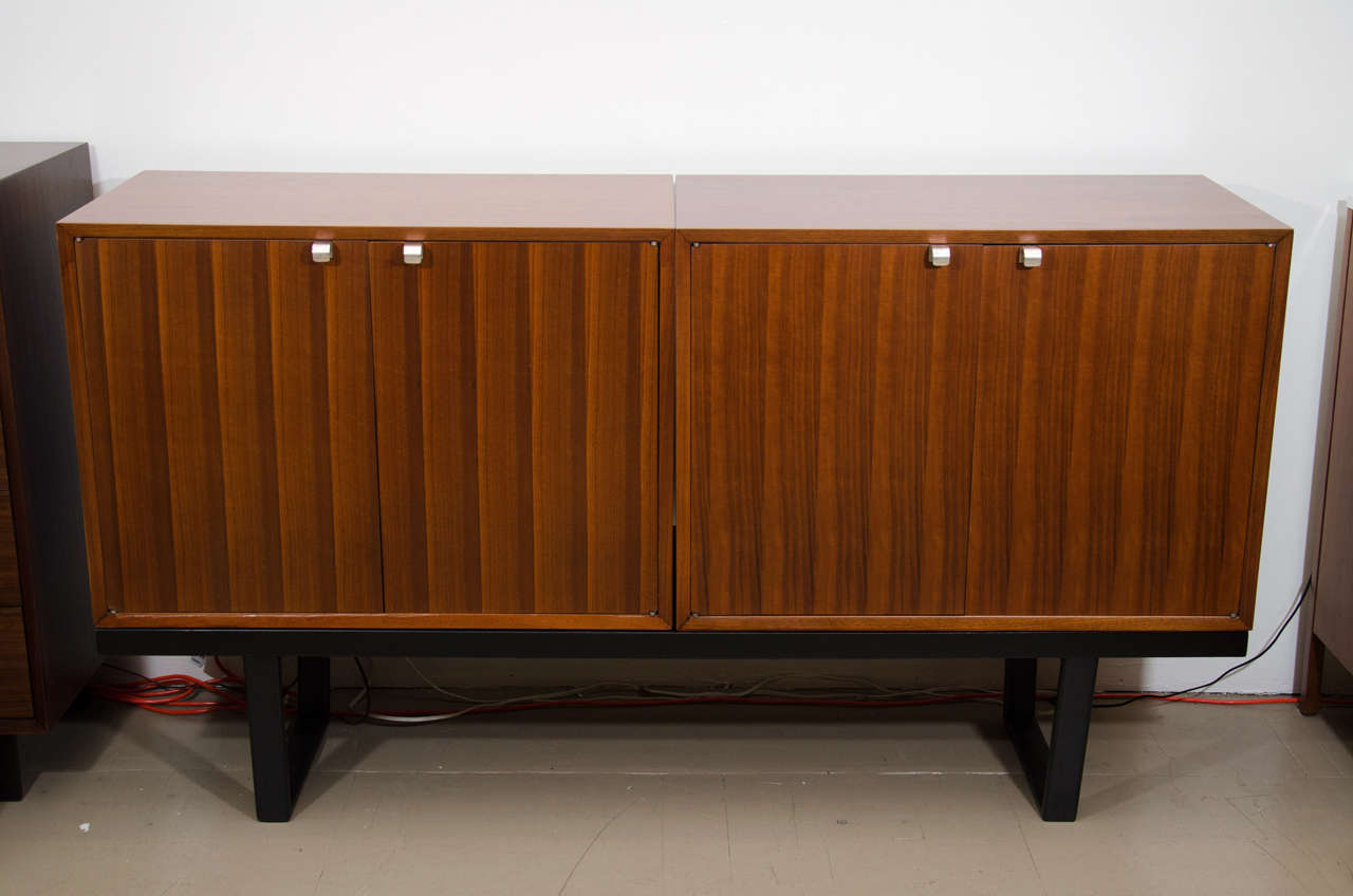 Pair of beautifully figured George Nelson walnut cabinets on black bench, mfg. Herman Miller
