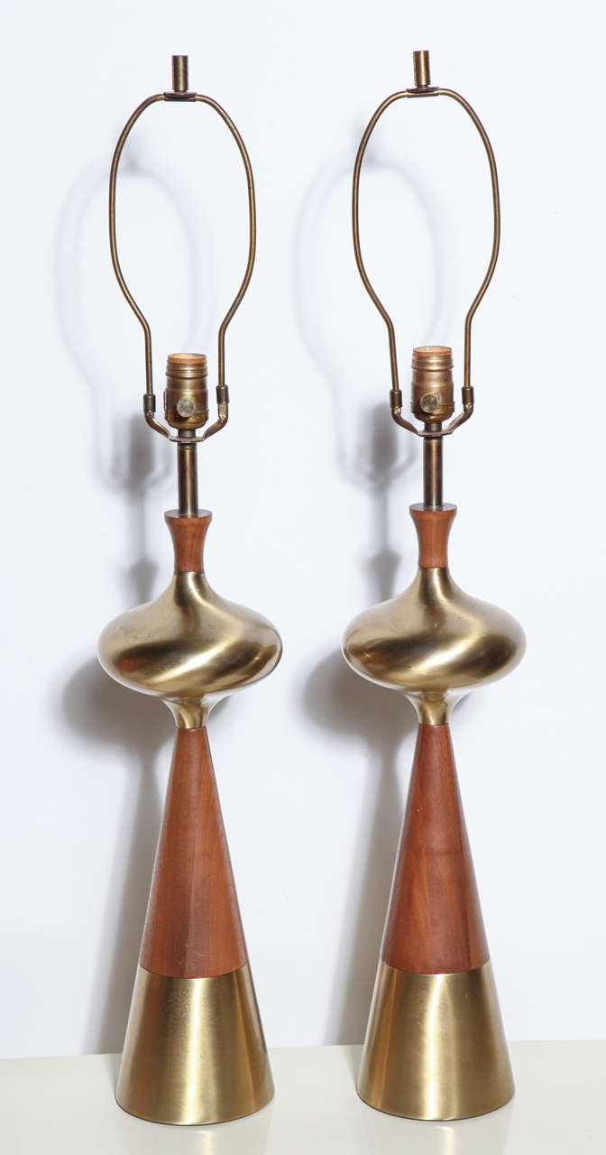 Substantial pair of Tony Paul for Westwood Industries Walnut and Brass Table Lamps, circa 1950. Featuring a tall corseted form with turned Walnut cap, cone stem, and Brass saucer and base. 24.5H to top of socket. Atomic. Sculptural. American Mid