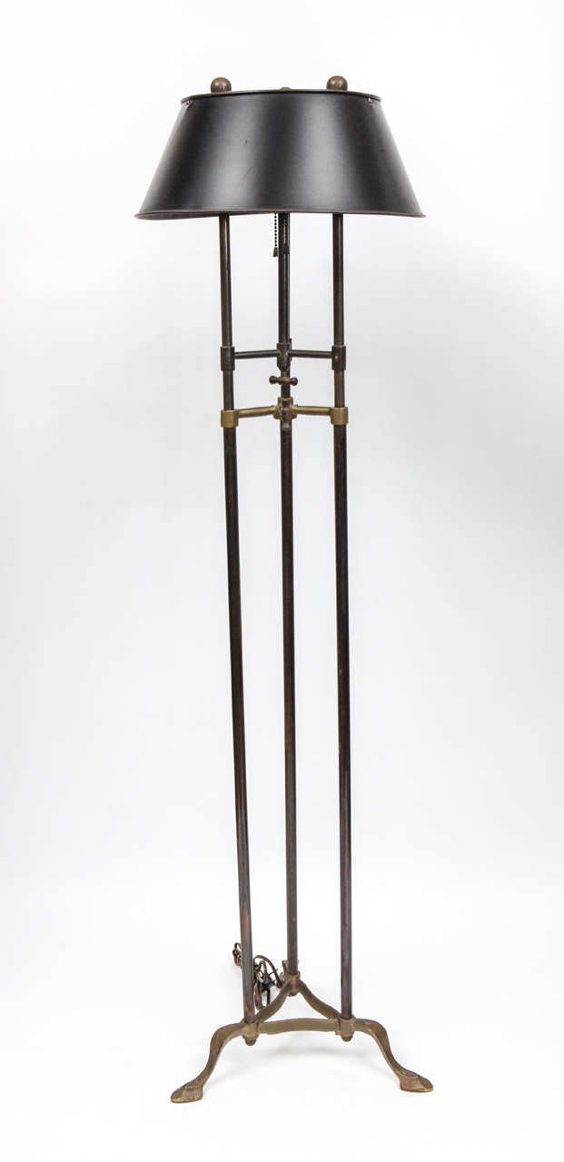 1960's Chapman floor lamp with modern styling and industrial features. This great floor lamp has three columns with two design elements of brackets with decorative handles.The three columns terminate in molded brass feet with a triagular base. The