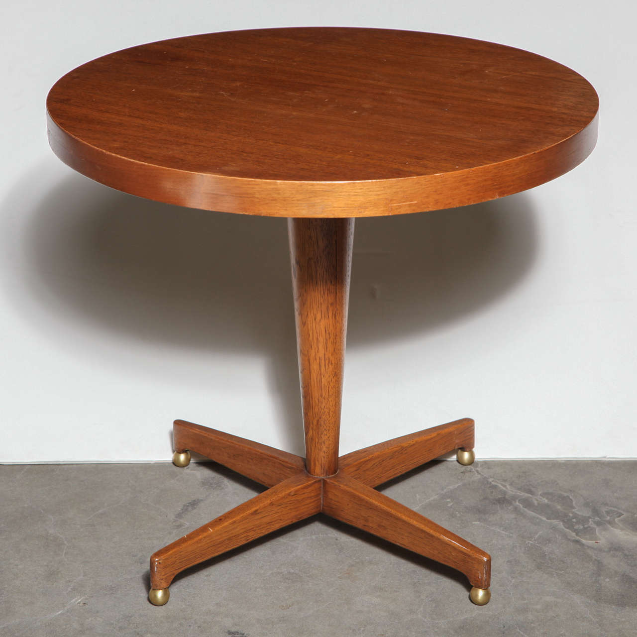 Mid-Century round wood side table with brass feet.