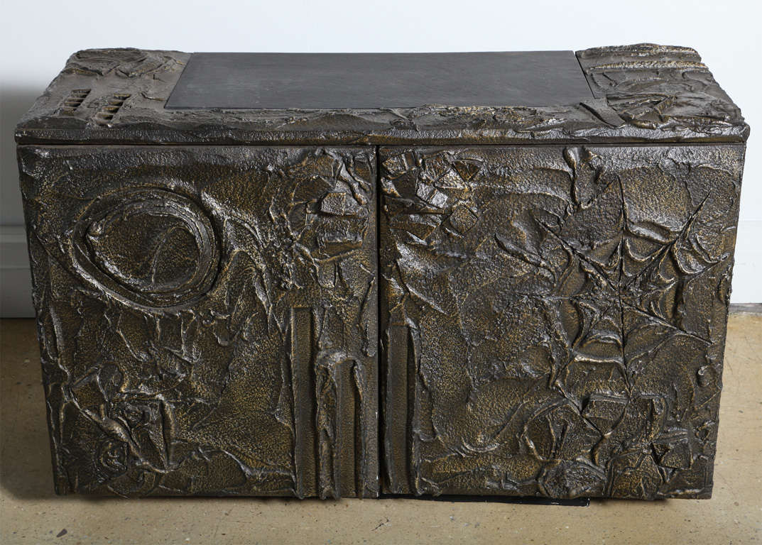 Early 1970s Paul Evans for Directional two-door credenza, floating sideboard with black slate inset. Constructed as a two door floating wall mount credenza
with abstract three dimensional rock like relief. Sculptural bronze powder
and resin. The