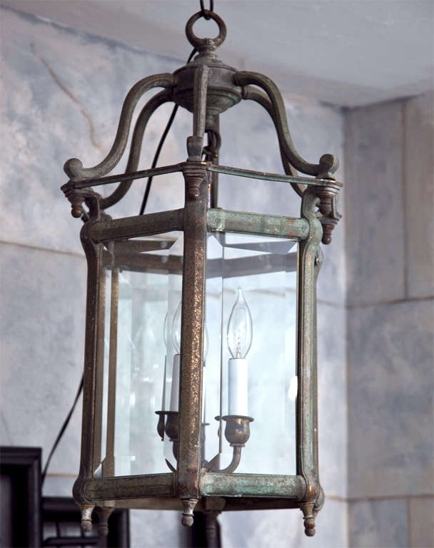 This classic Regency-style hexagonal bronze lantern has a soft greyish-green patina and stunning lines that make an elegant statement hanging in your front hallway, library or bathroom. Two of the beveled glass panes are original and we have