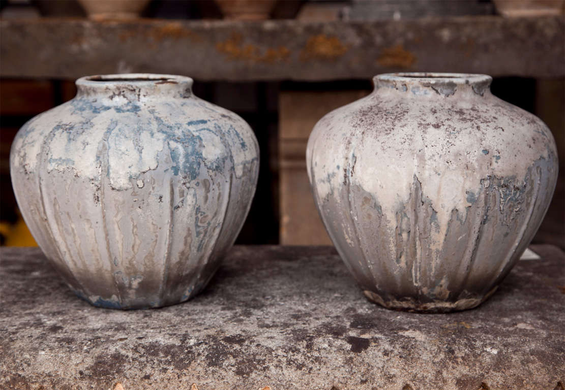 This pair of cast iron vases is very smart and the unique weathering pattern on the grey enameled surface gives them a very contemporary feel. Made and signed on the bottoms by the famous French foundry, Rosieres, they would make stunning accent