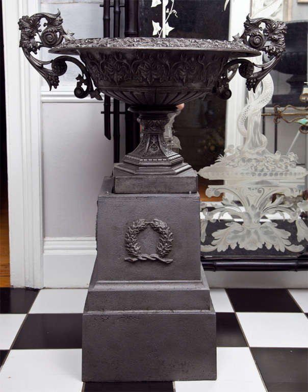 We have married this exceptional handled tazza urn to a conforming stepped and tiered cast iron plinth with wreath decoration to great effect. Both the urn and plinth have been polished and waxed and make a stunning statement. The urn, although