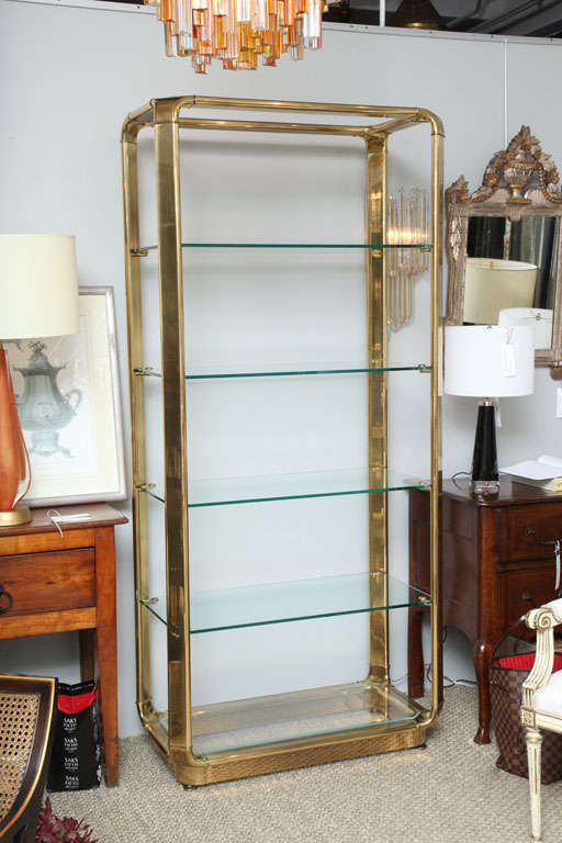 This very nice looking etagere has a brass frame and five glass shelves.  Its chamfered corners and brass shelf supports make it a beautifully finished piece.