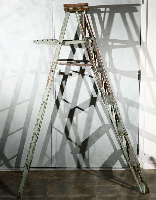 A vintage folding ladder, now suited as a stand for display, circa 1930's, with an old worn paint finish. Having a lot of character, this piece is well suited for any number of settings. 