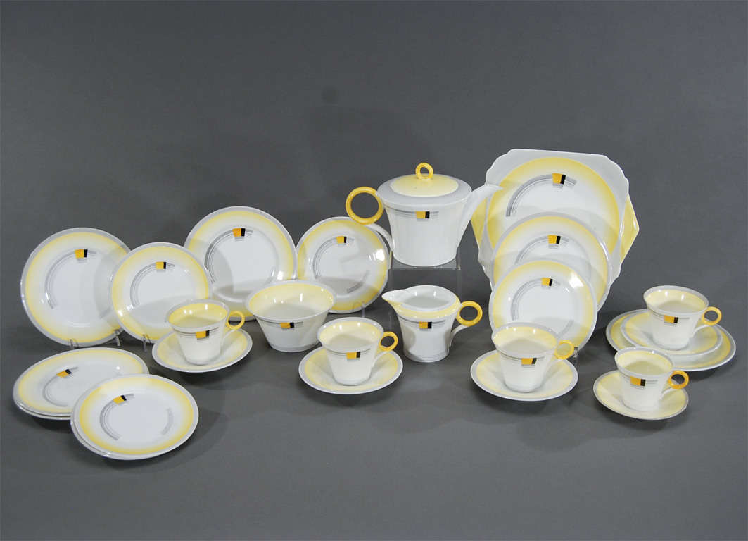 Set your table with this rare and complete teaset with bold Art Deco decoration, made by Shelley. The rare shape of the porcelain screams Art Deco, the colors and pattern complete the picture. The set includes four cups and saucers, one demitasse