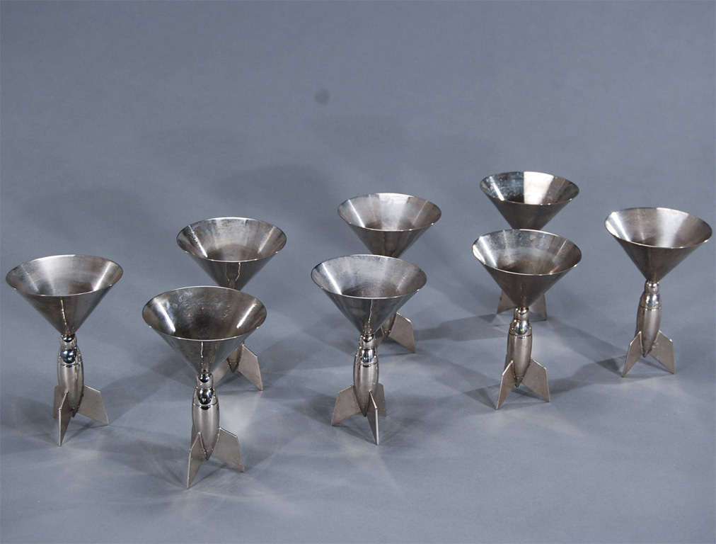 Wonderful for decorating a bar, this set of 8 chrome or polished steel Martini goblets evoke the Art Deco period. This set of 8 of Art Deco style Martini glasses are marked Godinger and the stem looks like a replica of Flash Gordon's rocket ship,
