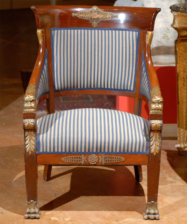 A wonderful Empire mahogany chair with gilded carved dolphins and acanthus leaf on arms. Claw ormolu gilt feet.