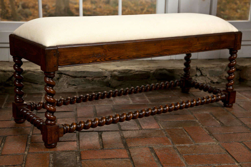 Made for us in England, this oak barley twist bench owes its appearance to the Jacobean era, when oak was the primary wood used in the construction of furniture that was beginning to become an art form. Handsome turnings, quality joinery and a