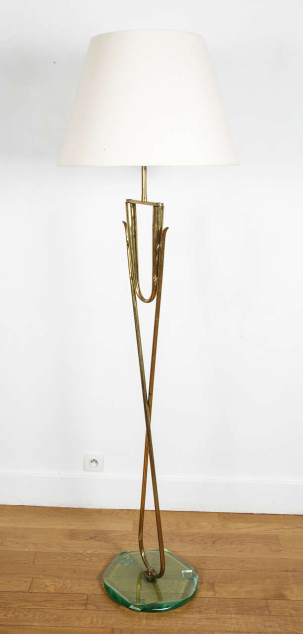 Gilt brass and glass floor lamp, Italy, 1960's.  
Bevelled glass circular base.  Tubular X foot with U, reflector.