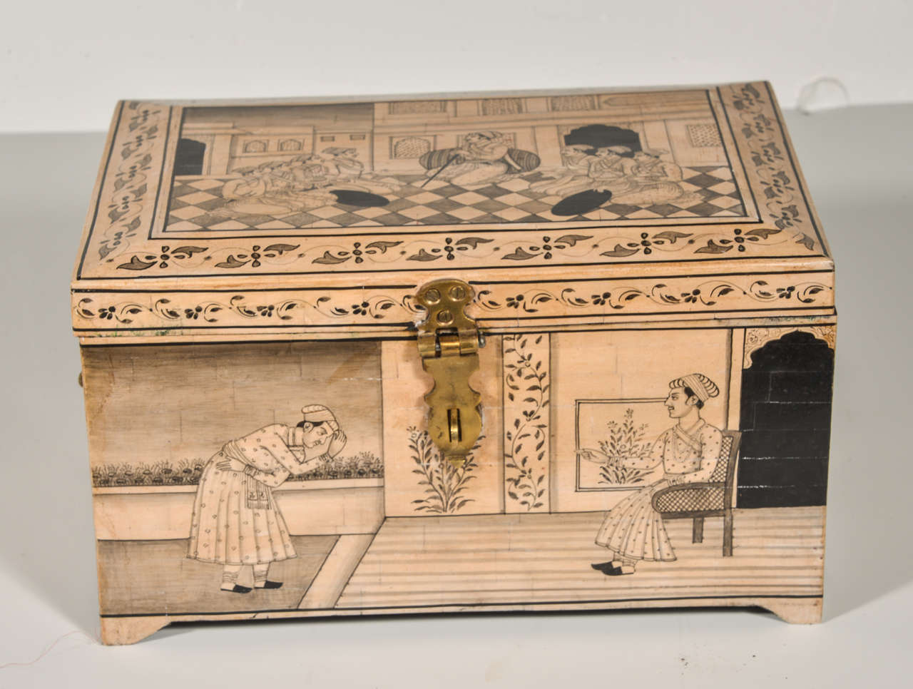 Box of camel bone veneer, incised decoration in black.  Brass handles on the side with a hinged lid.  Uttar Pradesh region of India.  Inner compartment tray with storage beneath and secret drawers on the side.