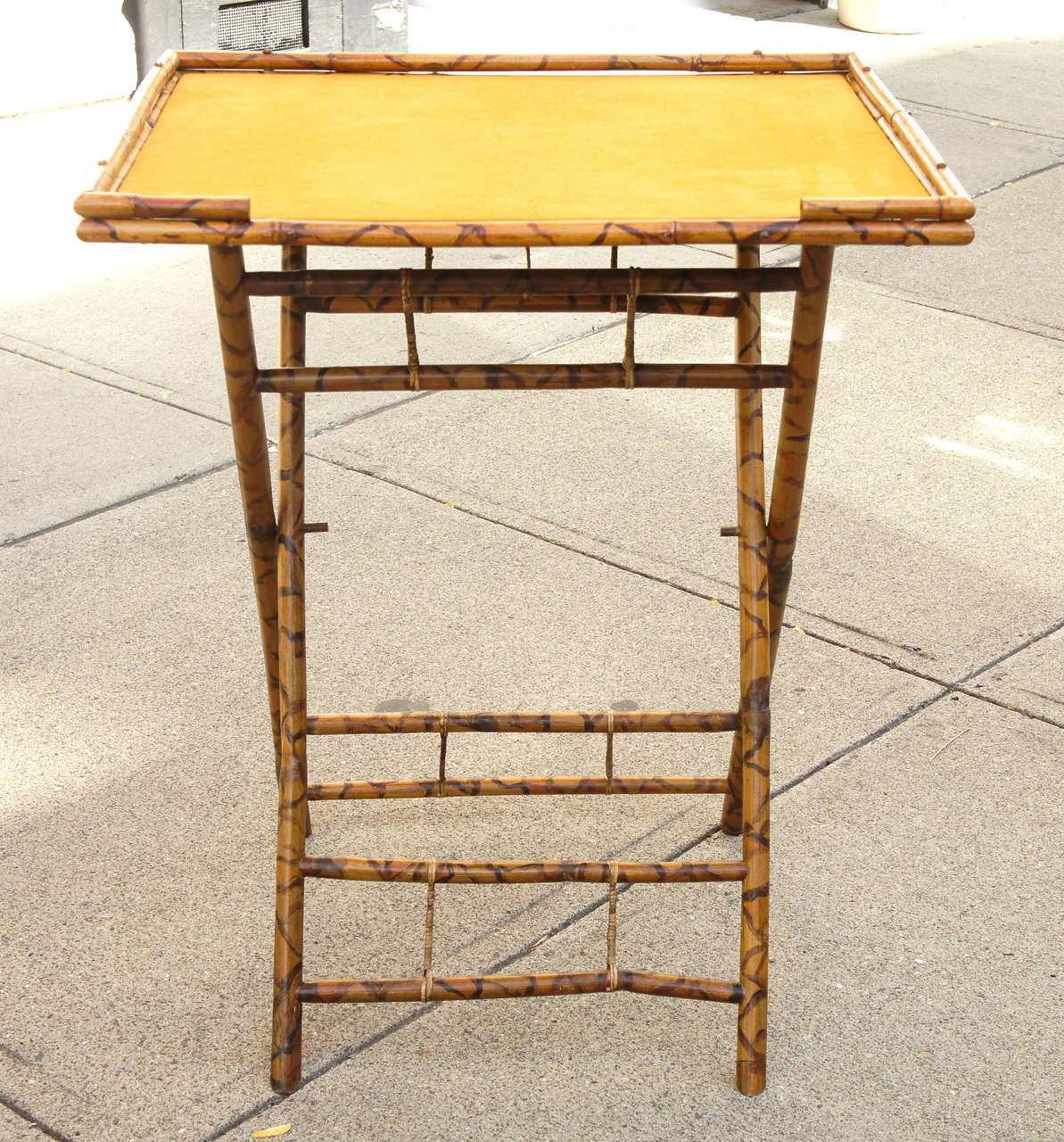 This late 19th or early 20th century folding table is constructed or burnt and stained bamboo.  English or American in manufacture the form is a standard Victorian form and used by all classes. Bamboo was considered in this time fashionable, exotic
