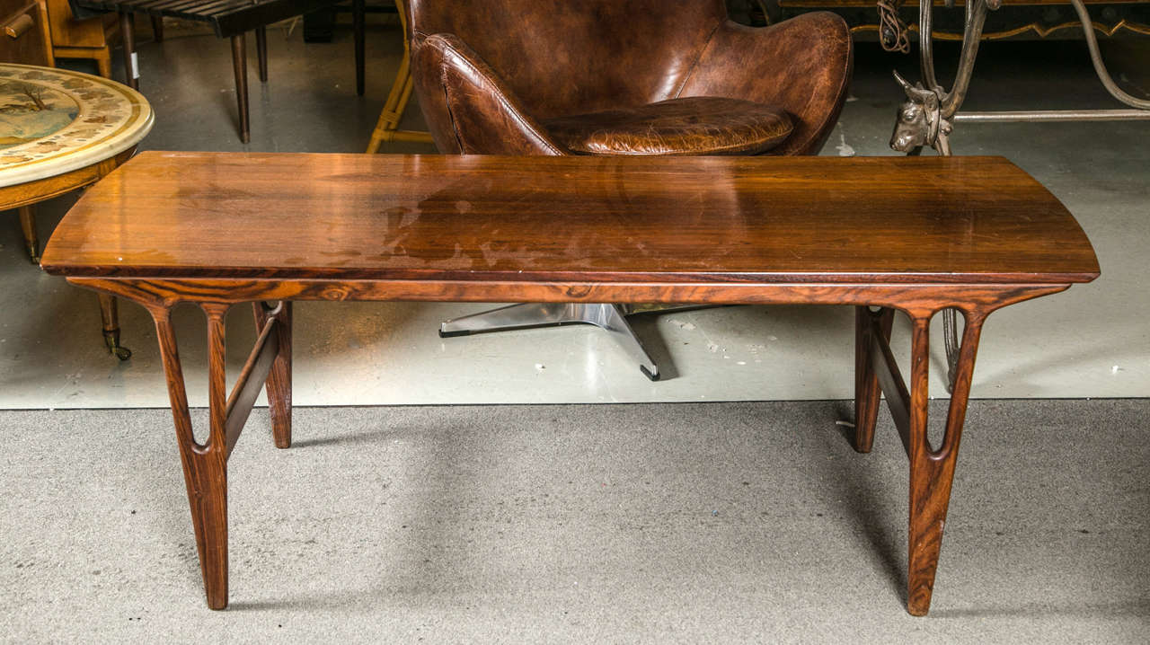Rosewood Danish Mid-Century Modern coffee table. This elegant coffee table of solid rosewood construction. The Art Deco styled legs with open fret work design supporting a fine solid top.