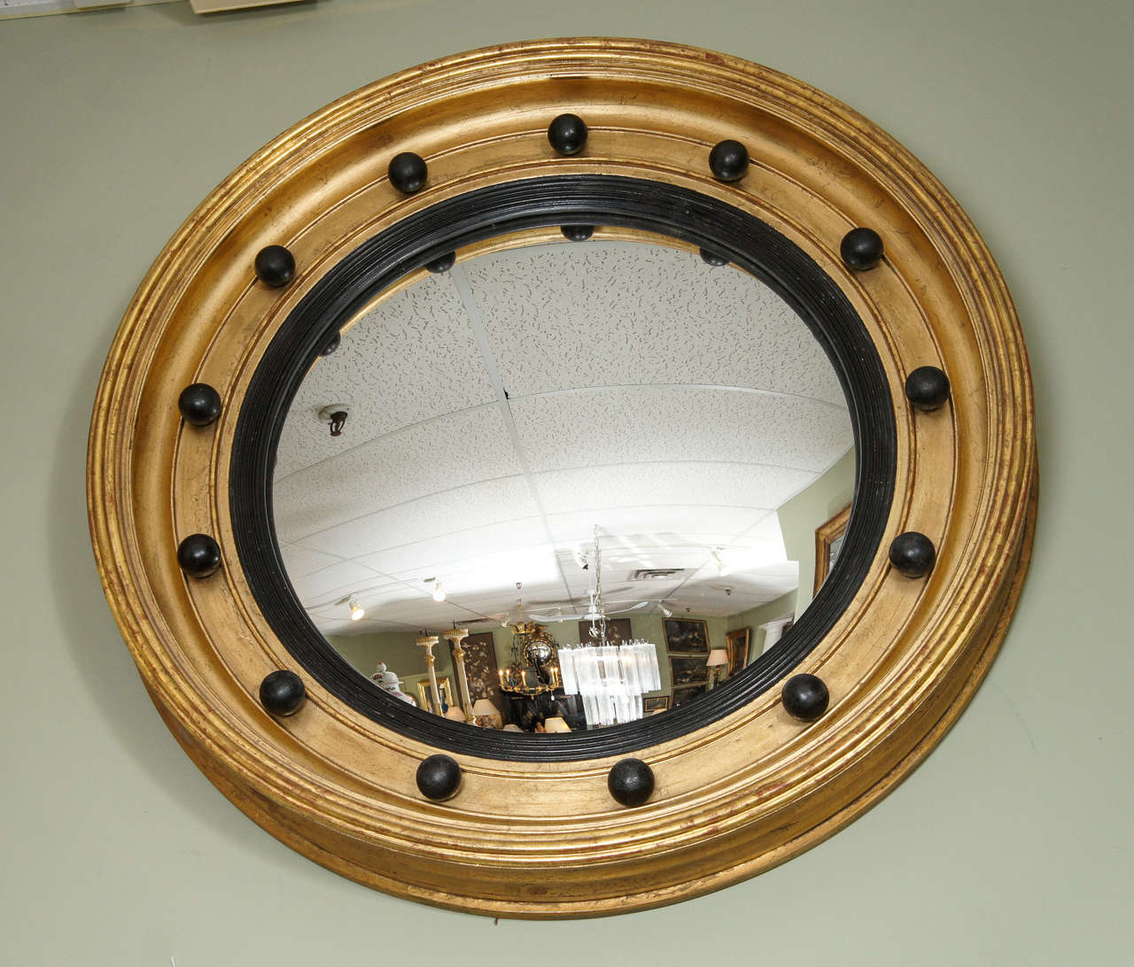Giltwood convex mirror with ebonized details.