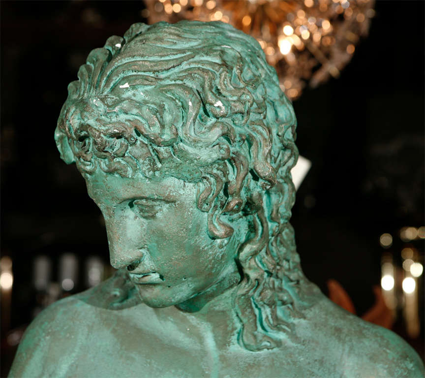 A male nude statue in green patina plaster. Made to look like aged copper or bronze.
