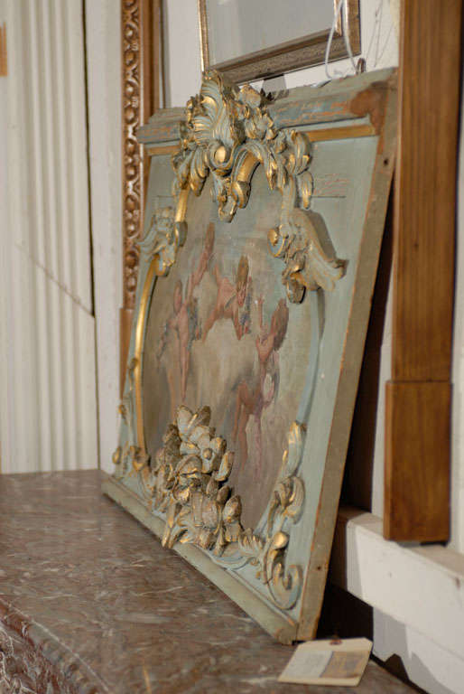 Pair of 19th. century carved French pine overdoor frames with the original finishes,- the painted panels with cherubs frollicking in the clouds. The matching carved wooden frames with central shells flanked by scrolls, with carved foliate detail,