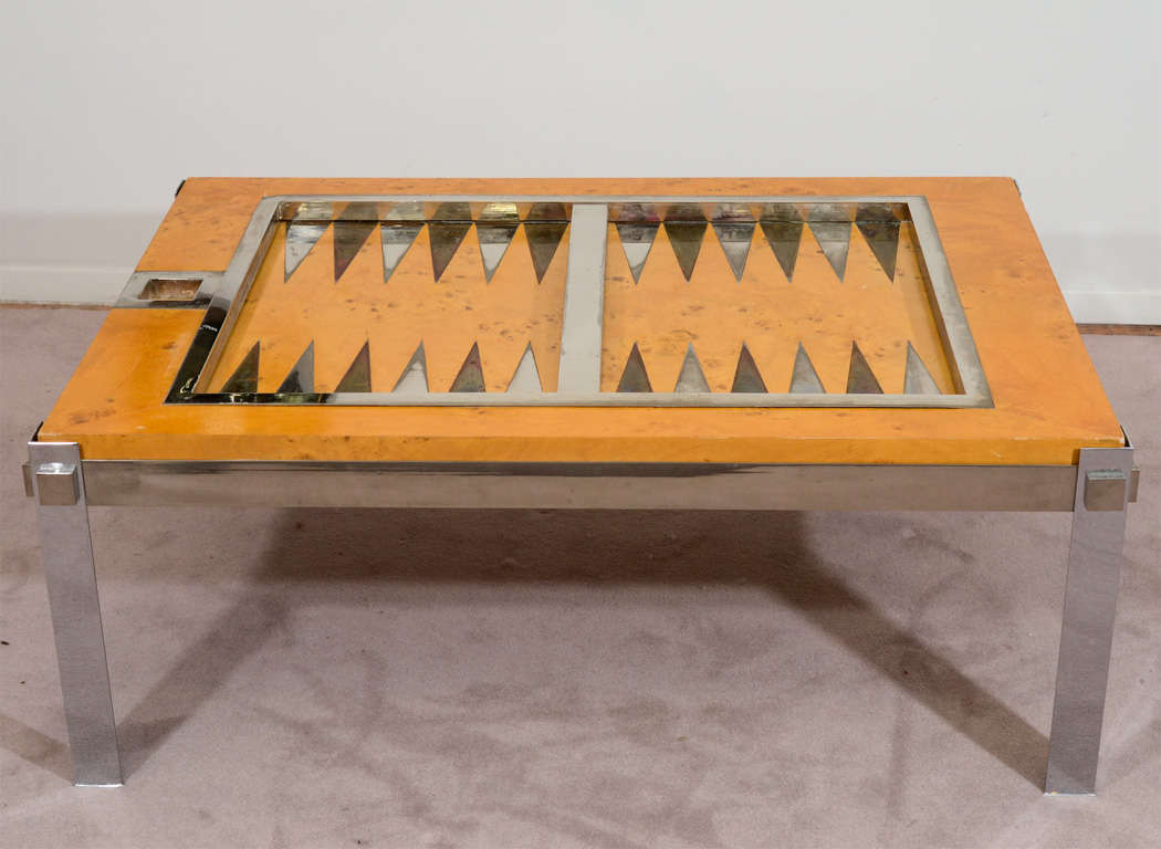 A vintage coffee or cocktail table with inset backgammon board by Tommaso Barbi. The piece is done in burl wood with chrome frame and brass and chrome game board detailing. The piece is covered in a thick clear Lucite surface and includes Thirty
