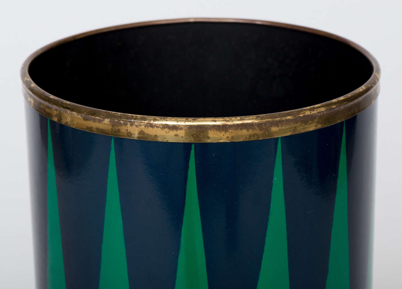 A Piero Fornasetti Umbrella Stand.
Lithographically printed and handpainted metal.
Brass feet and rim, with original drip tray.
Signature to base.
Italy, circa 1970.
56cm high and 26cm diameter.