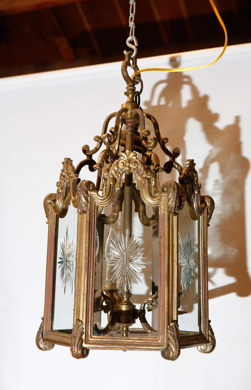 A good quality Rococo style interior hanging lantern having three lights, circa the 1950's. Each of the six glass panels have star burst cutting as decorative elements. This lantern will be a superior asset to any quality setting.