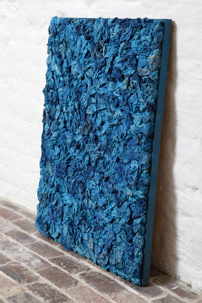 a work of art made by blue paper flowers