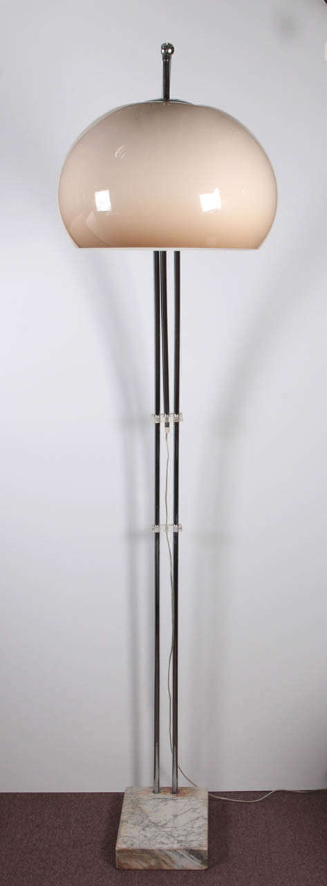An Italian arc floor lamp with thermoplastic opaque top in a shaded creme brulee coloration, tubular chrome extension with all original components and ending in marble plinth base.
This floor lamp is adjustable. The sweeping arc can be easily