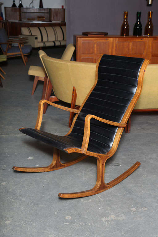 Mid-century Rocking Chair by Kosuga echoing the Danish Modern design style of Hvidt and Molgaard.  Features an oiled oak frame with rosewood inlay and a sleek channeled leather upholstery.
