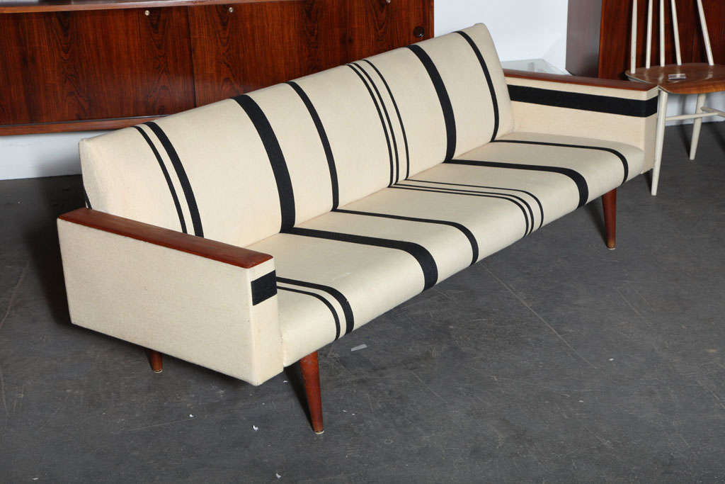 Handsome Streamlined Teak Sofa with Exposed Wooden Armrests by Illum Wikkelso.  Features original striped fabric in impeccable condition and tapered teak legs.