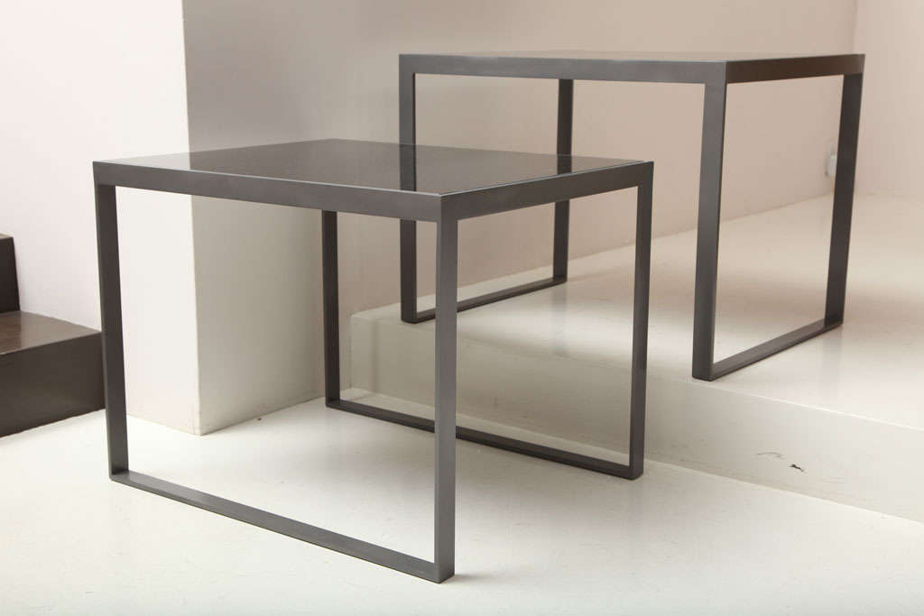 LIZ O'BRIEN EDITIONS near pair of tables with steel bases and black mirrored tops. The runner legs oriented in opposite directions.