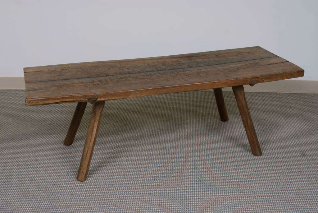 A two board oak pig bench cut to perfect coffee table height, the four splayed and chamfered legs through-tenoned to the 1.5