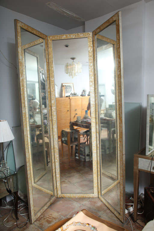 A classic framed mirrored 3 panel folding screen with mother of pearl tiles set within a silver leaf wood frame. May be used as a room divider, a vanity surround or dressing mirror.