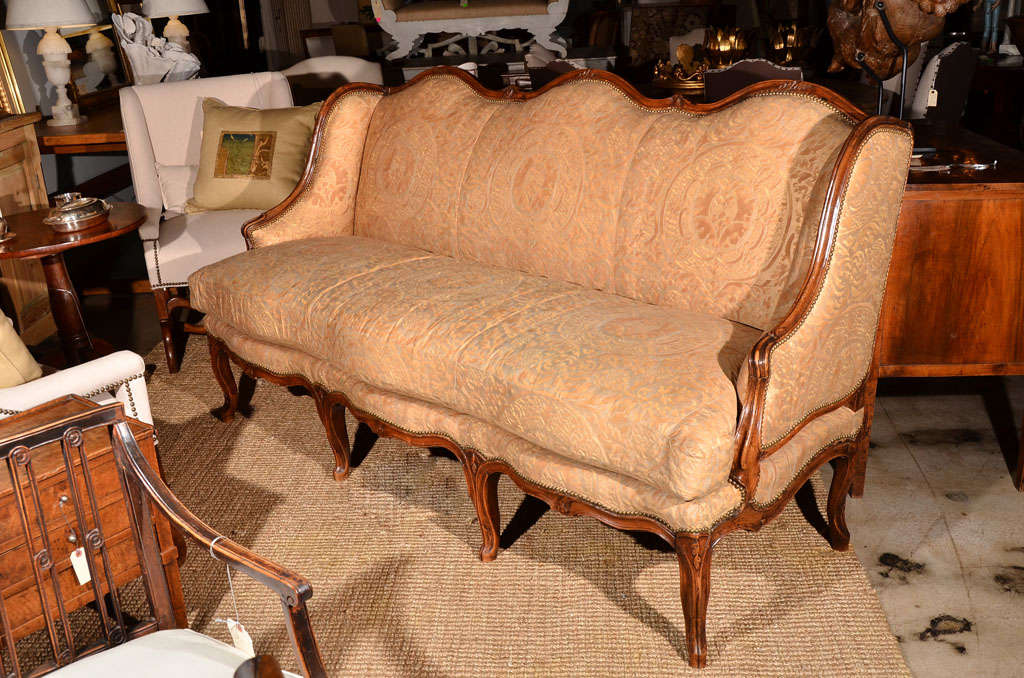 Gorgeous 18th century  Regence walnut canape with beautiful rococo lines from Lyon, France.<br />
Re-upholstered in vintage 