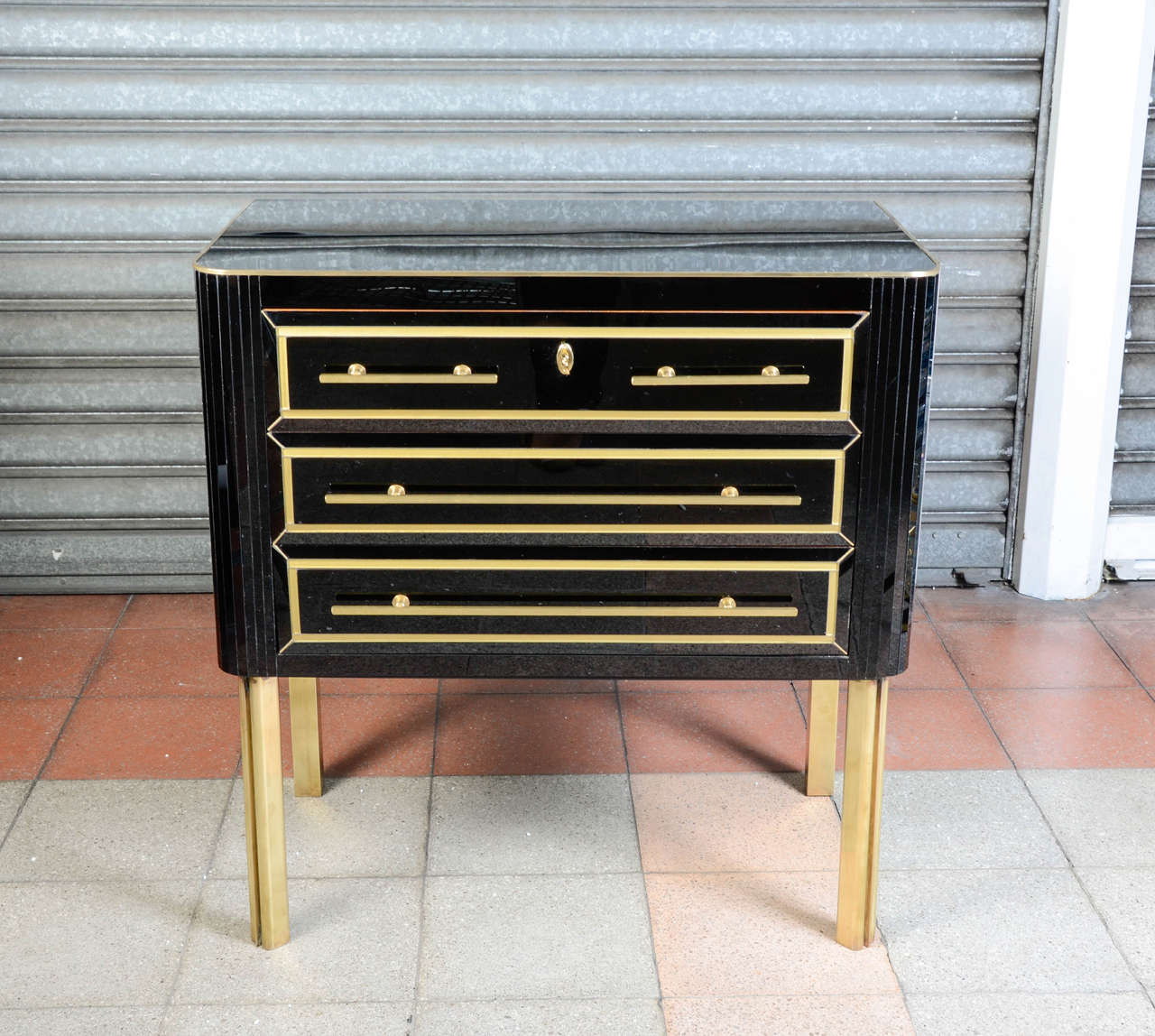 Pair of chest of three drawers, covered in black mirror, circa 1970.
Legs in brass.