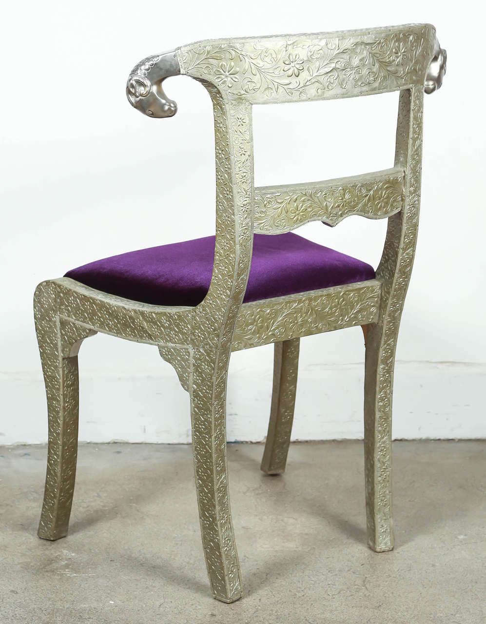 Anglo-Indian silvered wrapped clad side chair.
Anglo Raj wedding palace chair, hand-hammered with repousse silver metal work over wood with carved ram head finals and Moroccan purple velvet covered cushion, very nice and unusual.
Vintage