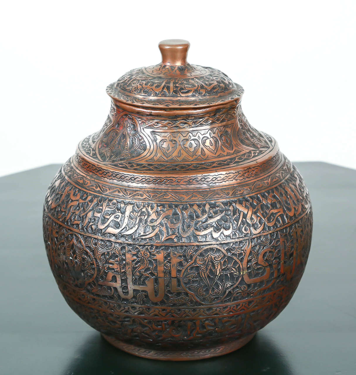 A Middle Eastern Persian Mameluke tinned copper jar with lid.
Heavily hand-hammered with Kufic Persian brass calligraphy all around and geometric Islamic interlace.