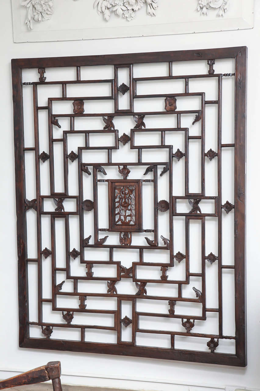 A large elmwood lattice panel from Zhejiang, China, late 19th century, with carved accents and floral center. A wall hanging, highly suitable for mirror backing.