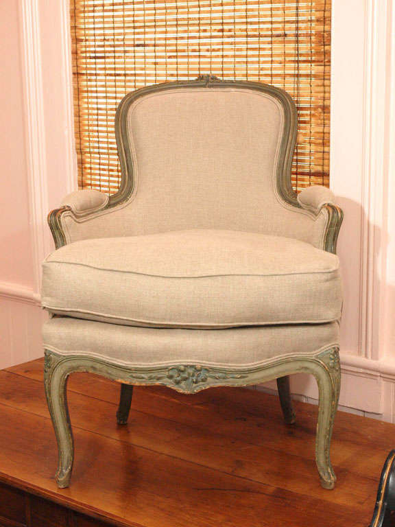 Louis XV style bergeres with painted wood frames.  Detailed carvings on frames and newly upholstered in beige linen.