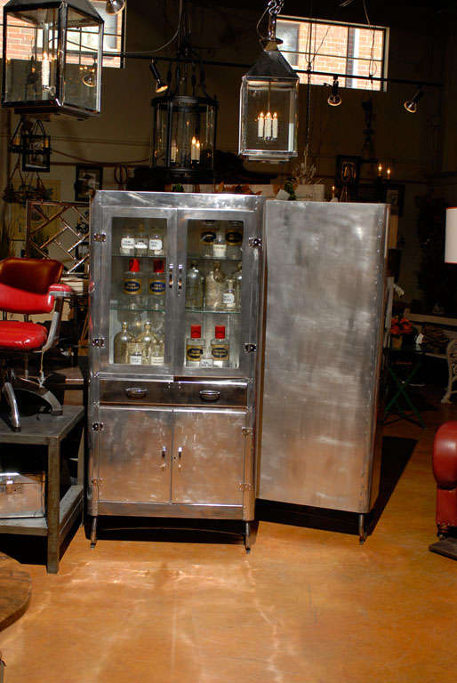 A vintage English polished aluminum and glass doors cabinet from the 1950s. This English aluminum cabinet from the mid 20th century features two glass doors over a long drawer and two lower doors. The double glass doors in the upper section open up