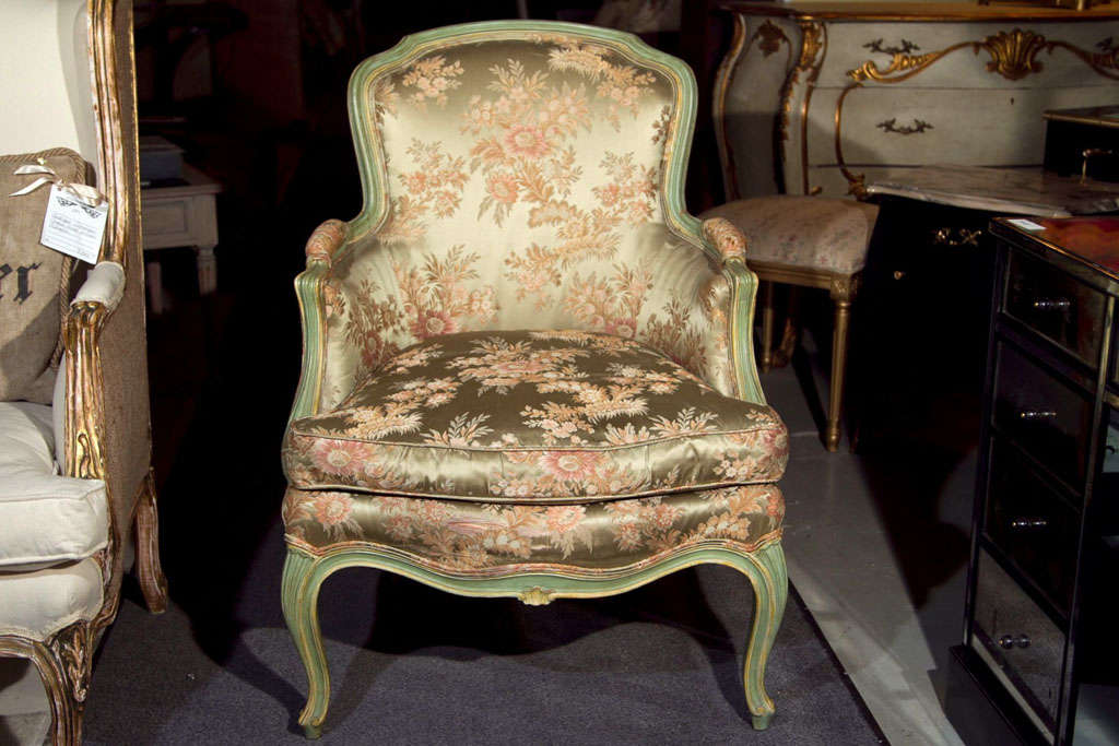 A pair of green painted bergere chairs, circa 1940, each with silk upholstery. The finely parcel-gilt and paint decorated frames are done in a stylish and fashionable green. Here you purchase simply the frames as the green upholstery would need to