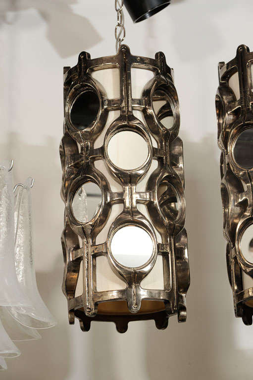 Spectacular pair of modern lantern<br />
style chandeliers with stylized<br />
resin frame in a moonglow finish<br />
with circular mirrored panels <br />
throughout.  Shown at 32