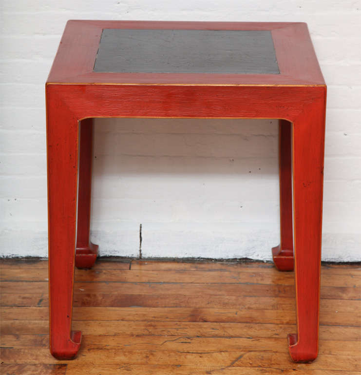 Cette table d'appoint Art déco chinoise en bois d'orme laqué rouge présente un plateau carré avec un insert en pierre de la cour de la dynastie Ming. La pierre noire crée un excellent contraste avec la laque rouge, une harmonie appréciée depuis des