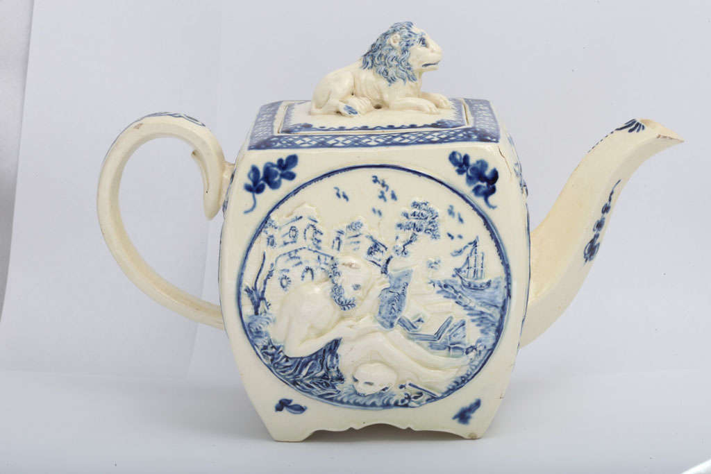 A rare creamware teapot molded with Saint Anthony, lion finial, decorated in underglaze blue